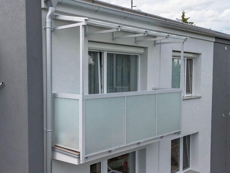 Opravený balkon s novým zábradlím a novou stříškou v rámci revitalizace panelového domu v Poděbradech